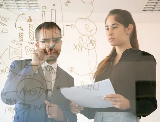 content-african-american-manager-writing-chart-on-glass-board