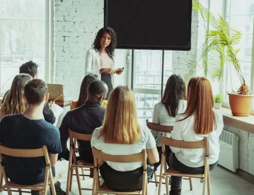 female-african-american-speaker-giving-presentation-in-hall-at-university-workshop