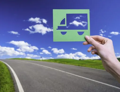 Hand holds green logistics symbol
